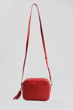 Load image into Gallery viewer, Aurora London red leather rectangular camera bag with long strap and gold-tone hardware.

