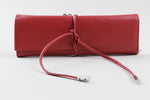 Load image into Gallery viewer, Birks red leather jewelry travel case with tie closure and interior organization pockets and straps.
