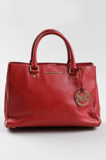 Load image into Gallery viewer, Michael Kors red leather rolled handle purse with gold MK medallion.
