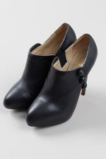 Load image into Gallery viewer, Christian Louboutin Black leather stiletto booties with button detail (38); Resoled with dustbag
