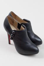 Load image into Gallery viewer, Christian Louboutin Black leather stiletto booties with button detail (38); Resoled with dustbag
